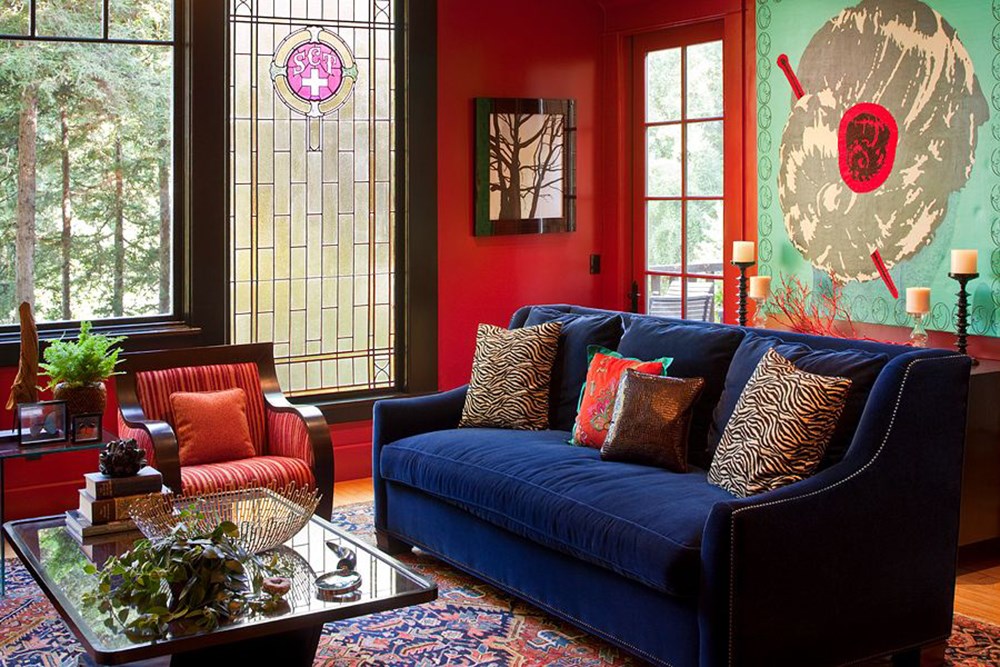 Синий диван в гостиной с красными стенами
