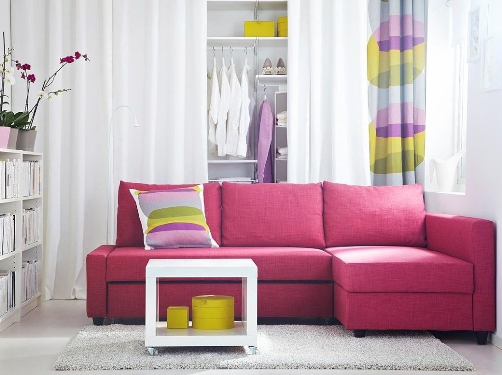 Небольшой угловой диван розового цвета с подушками