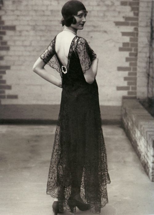 Девушка в длинном платье в стиле ретро 20-30 годов и туфлях на каблуках