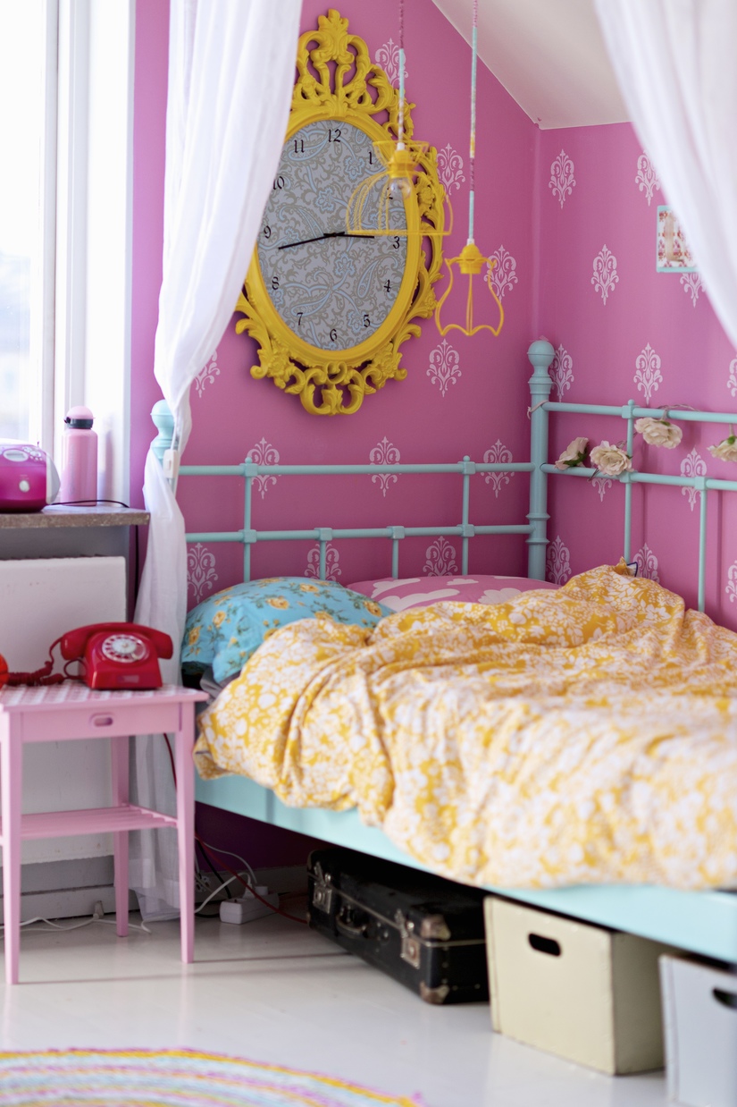 Розовые обои и золотистые часы в интерьере комнаты для девочки