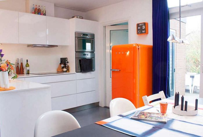 Оранжевый холодильник в кухне с белым гарнитуром