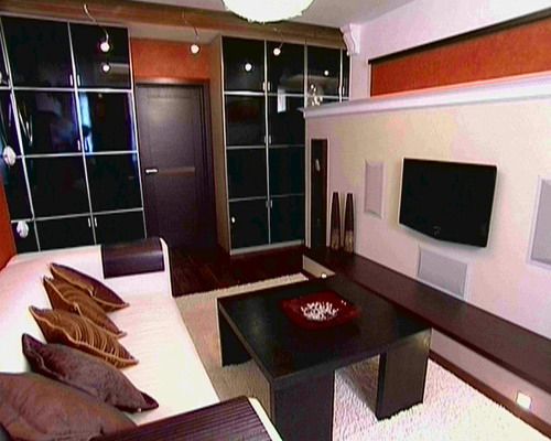 Черная мебель в гостиной с оранжевыми стенами